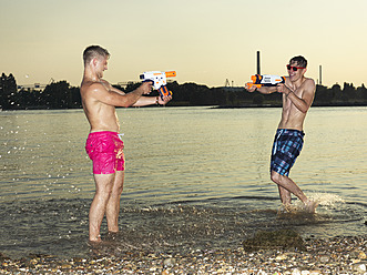 Deutschland, Düsseldorf, Junge Freunde spielen im Wasser - STKF000042