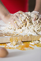 Germany, Young woman hands kneading batter - RFMYF000155