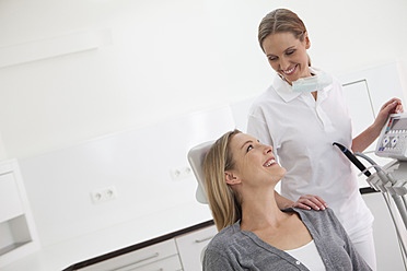 Germany, Dentist and patient in clinic, smiling - FMKYF000201