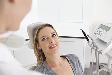 Germany, Mid adult woman in dentist chair, smiling - FMKYF000202