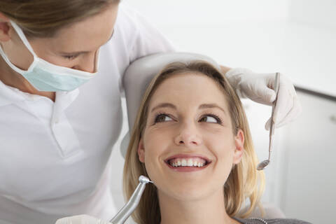 Germany, Young woman getting her teeth examined by dentist stock photo