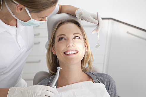 Germany, Young woman getting her teeth examined by dentist - FMKYF000213