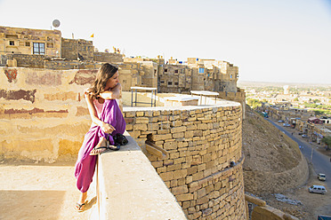 Indien, Rajasthan, Jaisalmar, Tourist sitzt auf der Mauer des Jaisalmar Forts - MBEF000515