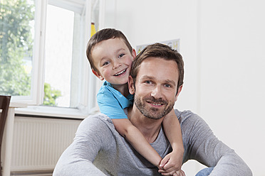 Germany, Berlin, Father and son at home, smiling, portrait - RBF001046