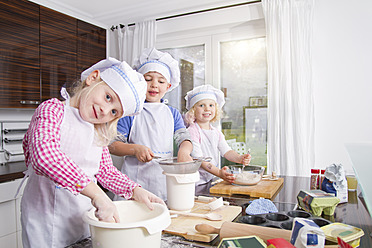 Deutschland, Mädchen und Junge machen Teig in der Küche - FKF000083