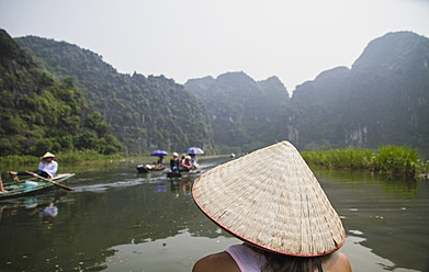 Vietnam, Ninh Binh, Junger Tourist auf Flussschwein in Tom Coc - MBEF000528