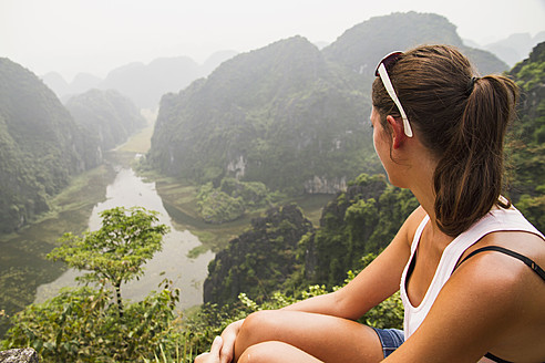 Vietnam, Ninh Binh, Junger Tourist mit Blick auf das Tom Coc Tal - MBEF000529