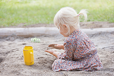 Deutschland, Mädchen spielt mit Sand auf Spielplatz - TCF002945