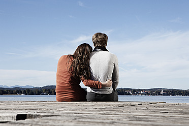 Germany, Bavaria, Couple sitting on jetty at Lake Starnberg - RBF001055