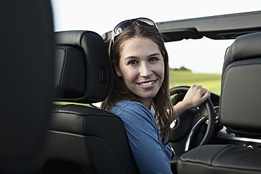 Germany, Bavaria, Young woman in car, smiling - RBF001084