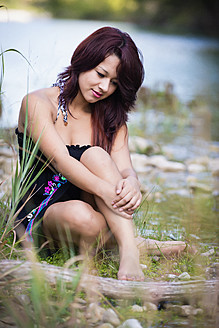 USA, Texas, Teenage girl sitting at Frio River - ABAF000297