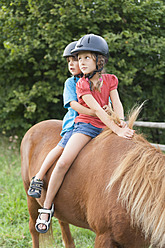 Deutschland, München, Mädchen lernen im Kindercamp reiten - TCF002995