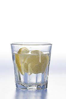 Glas Wasser mit Zitronenscheibe auf weißem Hintergrund - ASF004644