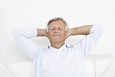 Spain, Senior man relaxing on couch, smiling - PDYF000119