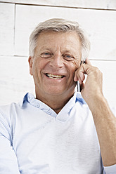 Spain, Senior man talking on mobile, smiling, portrait - PDYF000137