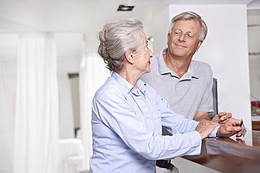 Spain, Senior couple with credit card waiting at reception - PDYF000175