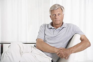 Spanien, Mallorca, Trauriger älterer Mann sitzt auf Couch - PDYF000190