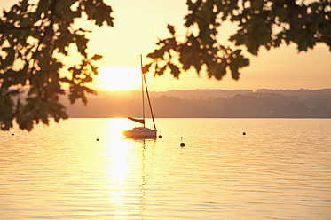 Germany, Bavaria, Sailing boat on Lake Ammersee at sunset - UMF000530