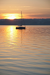 Deutschland, Bayern, Segelboot auf dem Ammersee bei Sonnenuntergang - UMF000518