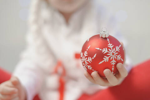 Junge hält Weihnachtskugel, Nahaufnahme, lizenzfreies Stockfoto