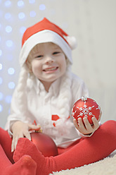 Junge mit Weihnachtskugel, lächelnd, Porträt - MJF000151