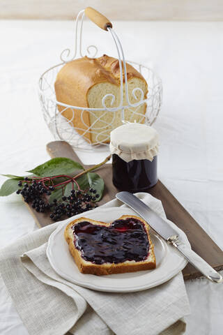 Holundermarmelade mit Weißbrot auf Holztisch, lizenzfreies Stockfoto