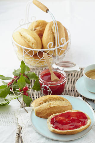 Kornelkirschkonfitüre mit Brötchen und Kaffee auf dem Tisch, lizenzfreies Stockfoto