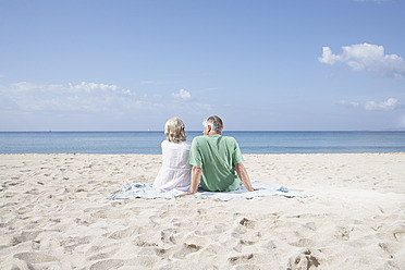 Spain, Mallorca, Senior couple sitting at beach - PDYF000204