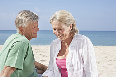 Spain, Mallorca, Senior couple sitting at beach - PDYF000205