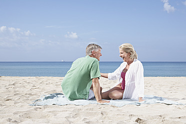 Spain, Mallorca, Senior couple sitting at beach - PDYF000206