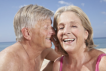Spanien, Mallorca, Glückliches Seniorenpaar am Strand sitzend - PDYF000210