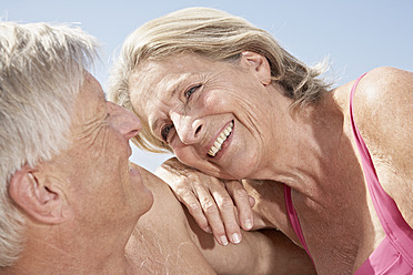 Spain, Mallorca, Happy senior couple sitting at beach - PDYF000276