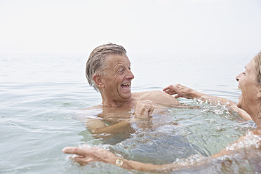 Spanien, Seniorenpaar beim Schwimmen im Meer - PDYF000247