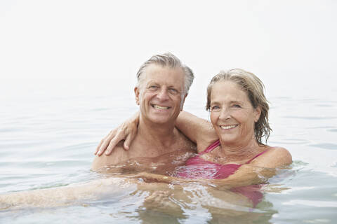 Spanien, Seniorenpaar beim Schwimmen im Meer, lizenzfreies Stockfoto