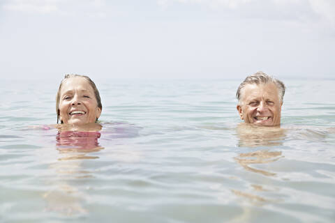 Spanien, Seniorenpaar beim Schwimmen im Meer, lizenzfreies Stockfoto