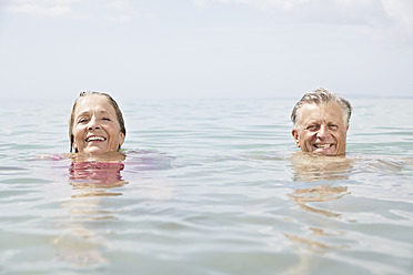 Spanien, Seniorenpaar beim Schwimmen im Meer - PDYF000243