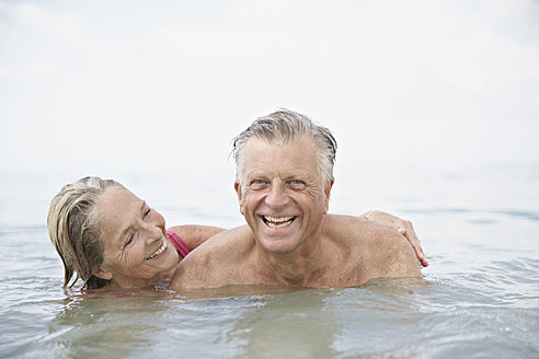 Spanien, Seniorenpaar beim Schwimmen im Meer - PDYF000238