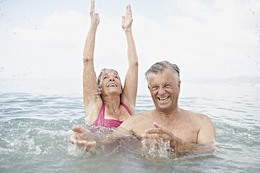 Spanien, Seniorenpaar beim Schwimmen im Meer - PDYF000236