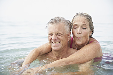 Spain, Senior couple swimming in sea - PDYF000235