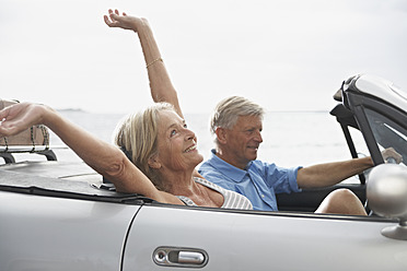 Spain, Senior couple in convertible car, smiling - PDYF000230