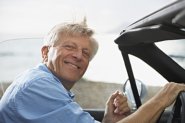 Spain, Senior man in convertible car, smiling, portrait - PDYF000228