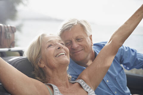 Spain, Senior couple in convertible car, smiling stock photo