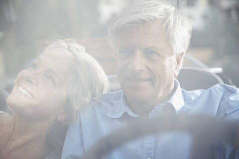 Spain, Senior couple behind glass window, smiling stock photo