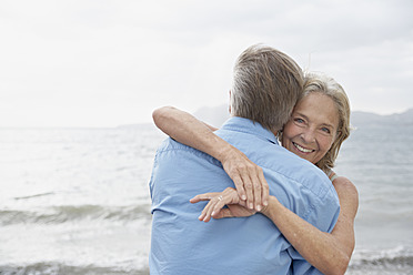Spain, Mallorca, Senior couple embracing on beach - PDYF000217