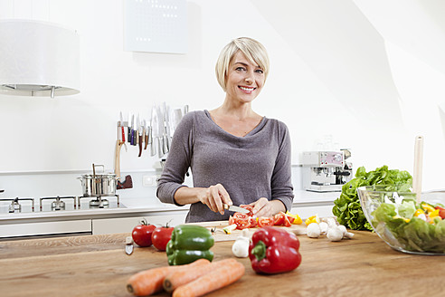 Deutschland, Bayern, München, Frau bereitet Essen in Küche vor - RBYF000227