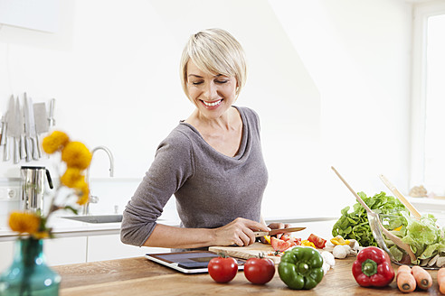 Germany, Bavaria, Munich, Woman preparing food in kitchen - RBYF000229