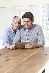 Germany, Bavaria, Munich, Mature couple using digital tablet, smiling - RBYF000279