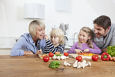 Deutschland, Bayern, München, Familie bereitet Essen vor, Junge füttert Mutter - RBYF000293