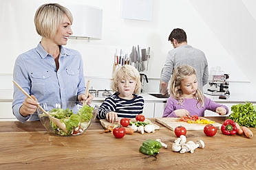 Germany, Bavaria, Munich, Family preparing food in kitchen - RBYF000294