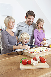 Deutschland, Bayern, München, Familie bereitet Pizza in der Küche zu - RBYF000297